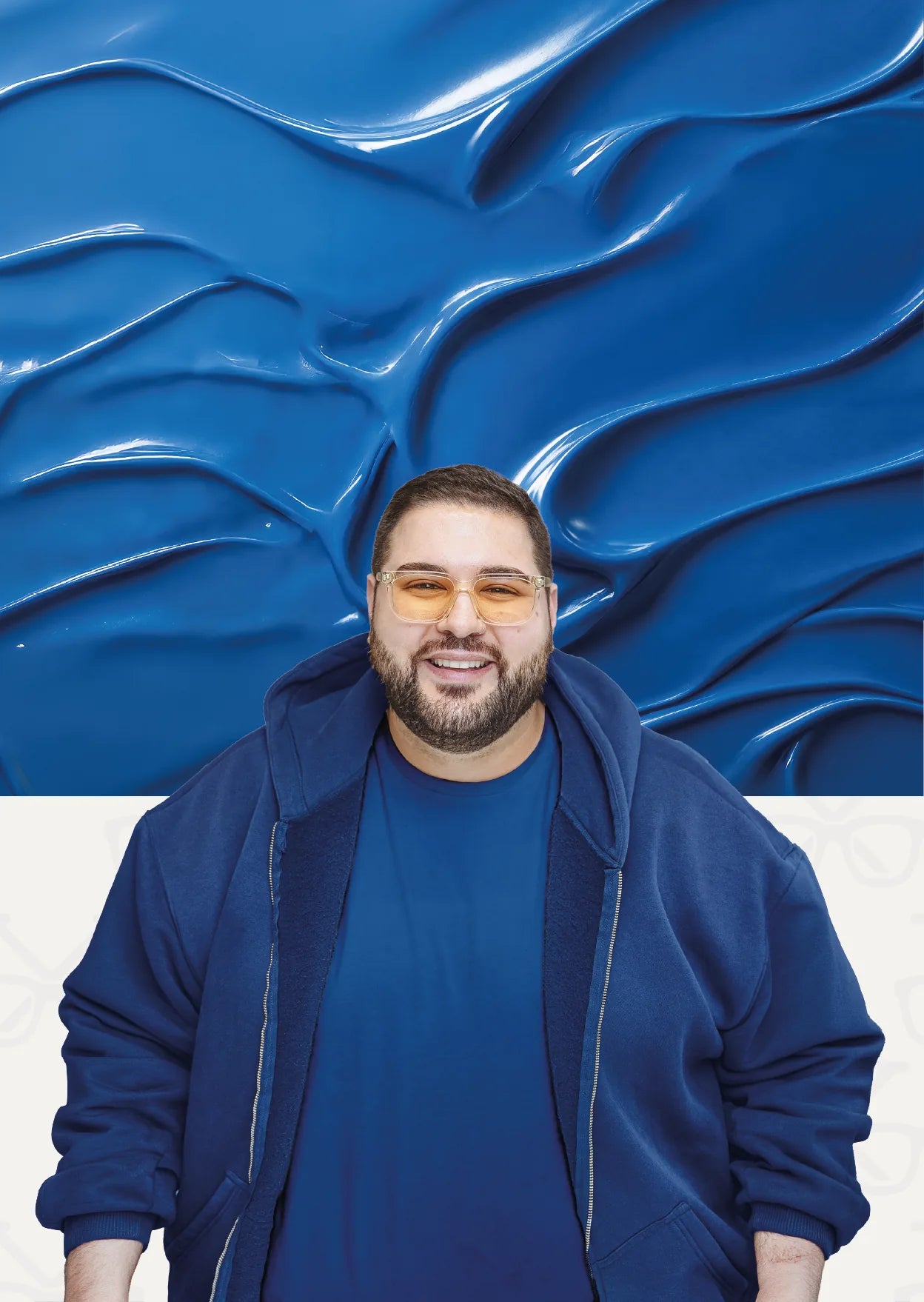 Leon souriant, avec des lunettes teintées et un sweat à capuche bleu